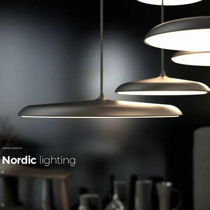 Modern black ufo pendant light with sleek matte metal discs and thin cords as a stylish dining room light source
