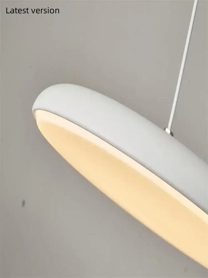 Modern pendant light with sleek elongated oval shape matte white finish ideal as a dining room light source