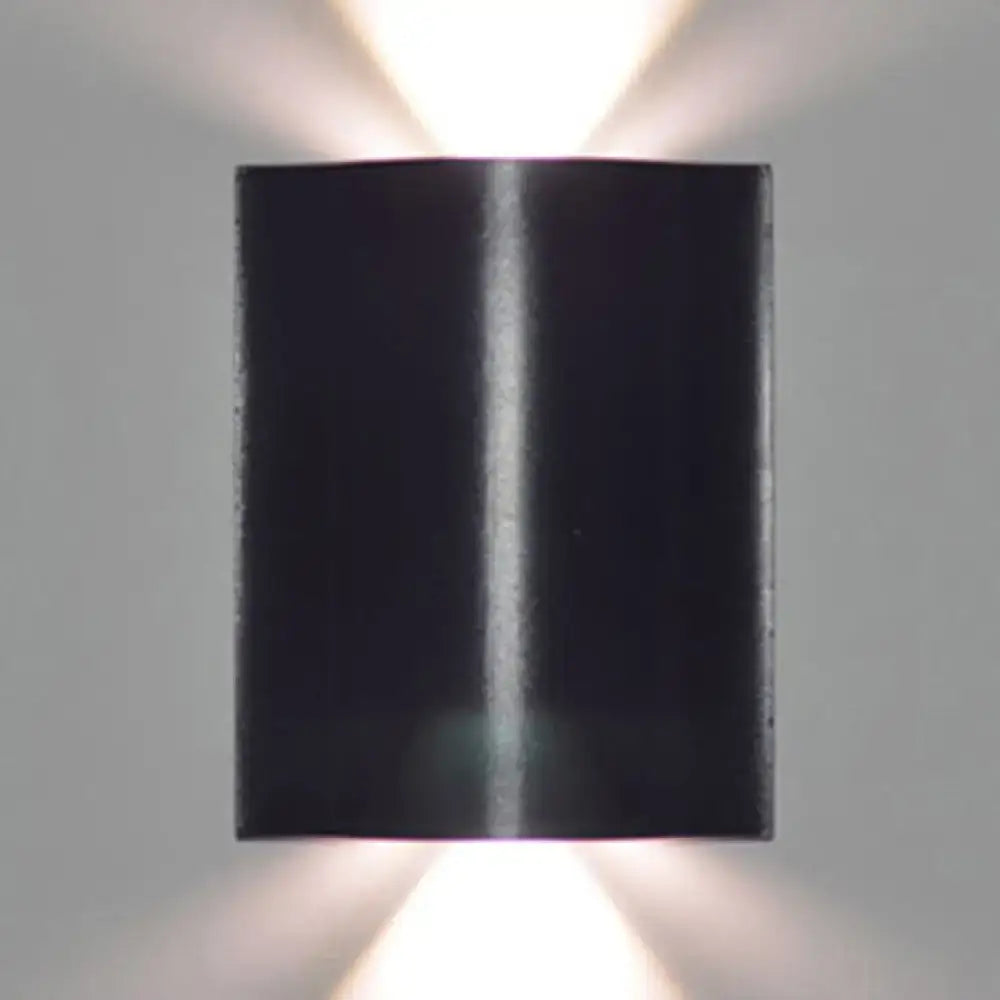 Modern black wavy wall washer lamp with sleek metallic finish and dual upward lights providing warm white lighting