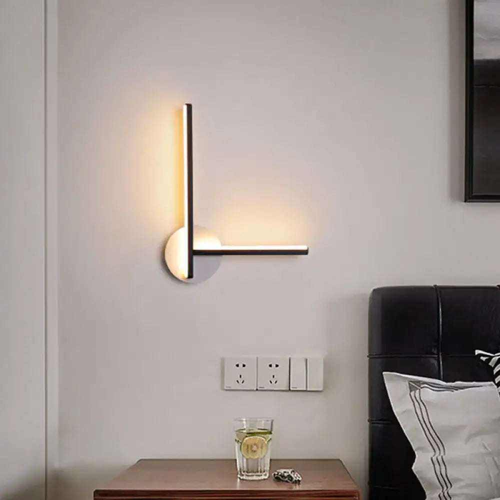 Modern black and white acrylic cross wall sconce with sleek metal frame and warm white light for bedroom use