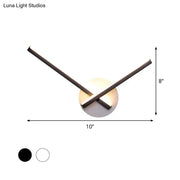 Modern black and white acrylic cross wall sconce with two intersecting arms emitting warm white light for bedroom use