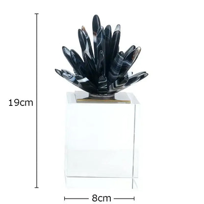Modern black and white crystal art featuring a glossy black agate flower sculpture on a clear acrylic base