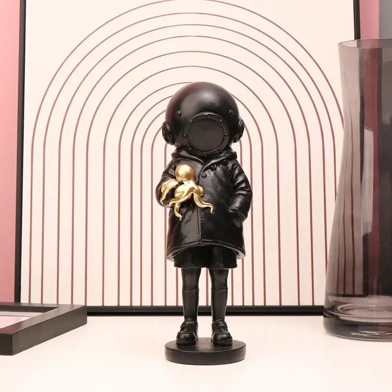 Modern black resin diver sculpture ornament of a child in vintage helmet holding a golden octopus for office decor
