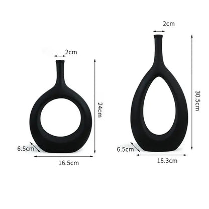 Two sleek black decorbites ceramic vases with oval bodies and circular cutouts for modern living room decor
