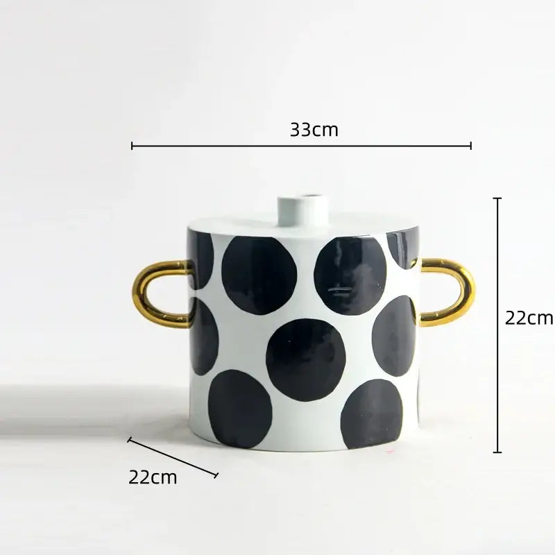 White ceramic vase with black white dots geometric pattern and gold-tone handles for living room decor