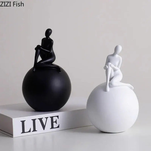 Modern black and white abstract human figurines seated on smooth geometric base character statues for living room decorbites geometric base decor