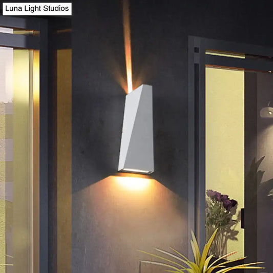 Modern black and white geometric nord wall sconce with warm amber light casting focused beams upward and downward