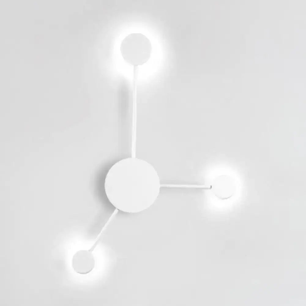 Minimalist white wall sconce light fixture with three glowing circular bulbs in a modern geometric design for living rooms