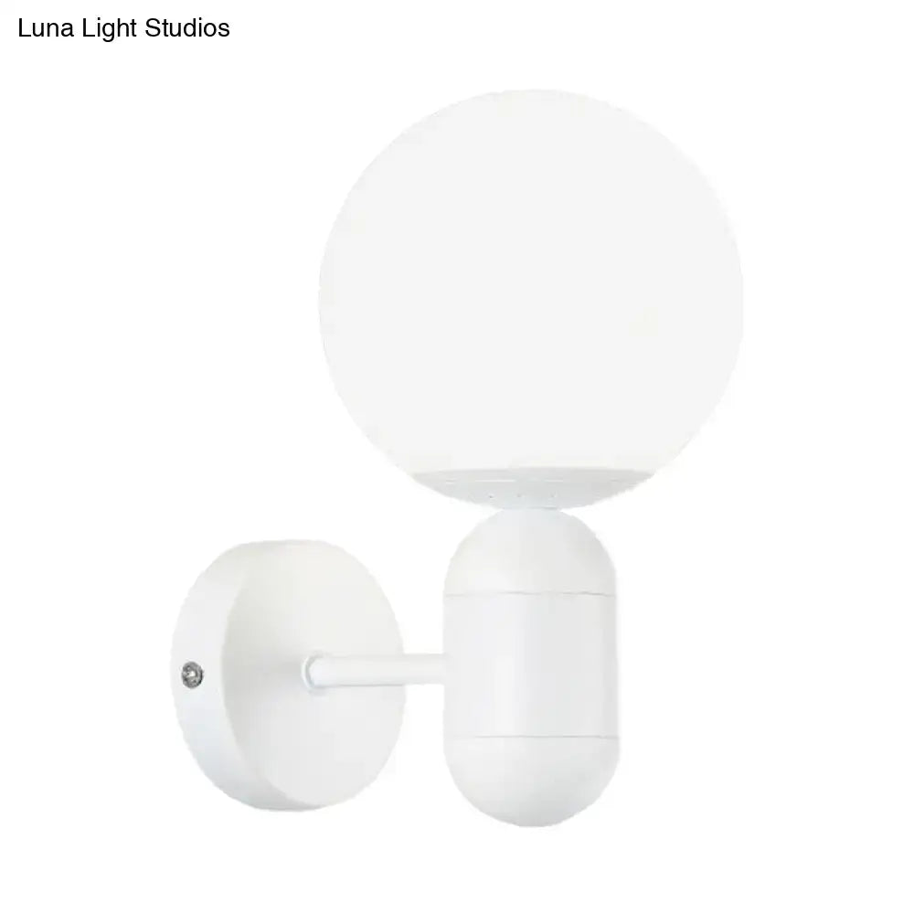 Modern black and white glass wall light featuring a white spherical globe wall lamp with a minimalist matte finish