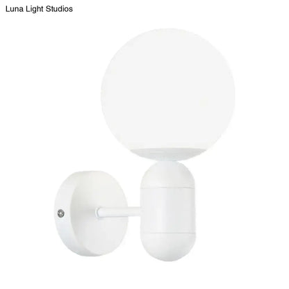 Modern black and white glass wall light featuring a white spherical globe wall lamp with a minimalist matte finish