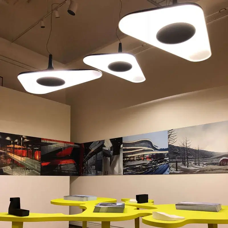 Modern black and white irregular pendant light with white triangular shades and black circular cutouts for dining room decorbites
