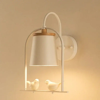 Modern black and white led bird wall sconce by decorbites featuring white ceramic shade, curved metal frame, and wooden accents
