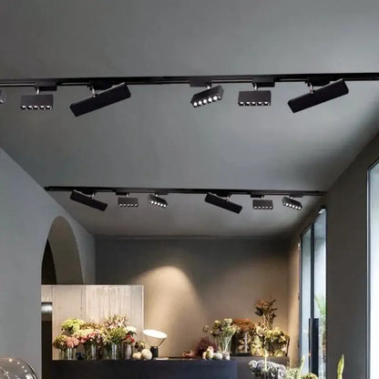 Modern black led linear grille track spotlights with adjustable heads mounted on a living room ceiling