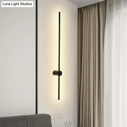Modern black led metal wall sconce with sleek vertical bar and cylindrical base for indoor lighting in living room