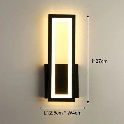 Modern black-framed led wall light with rectangular panel emitting warm yellow illumination for bedroom use