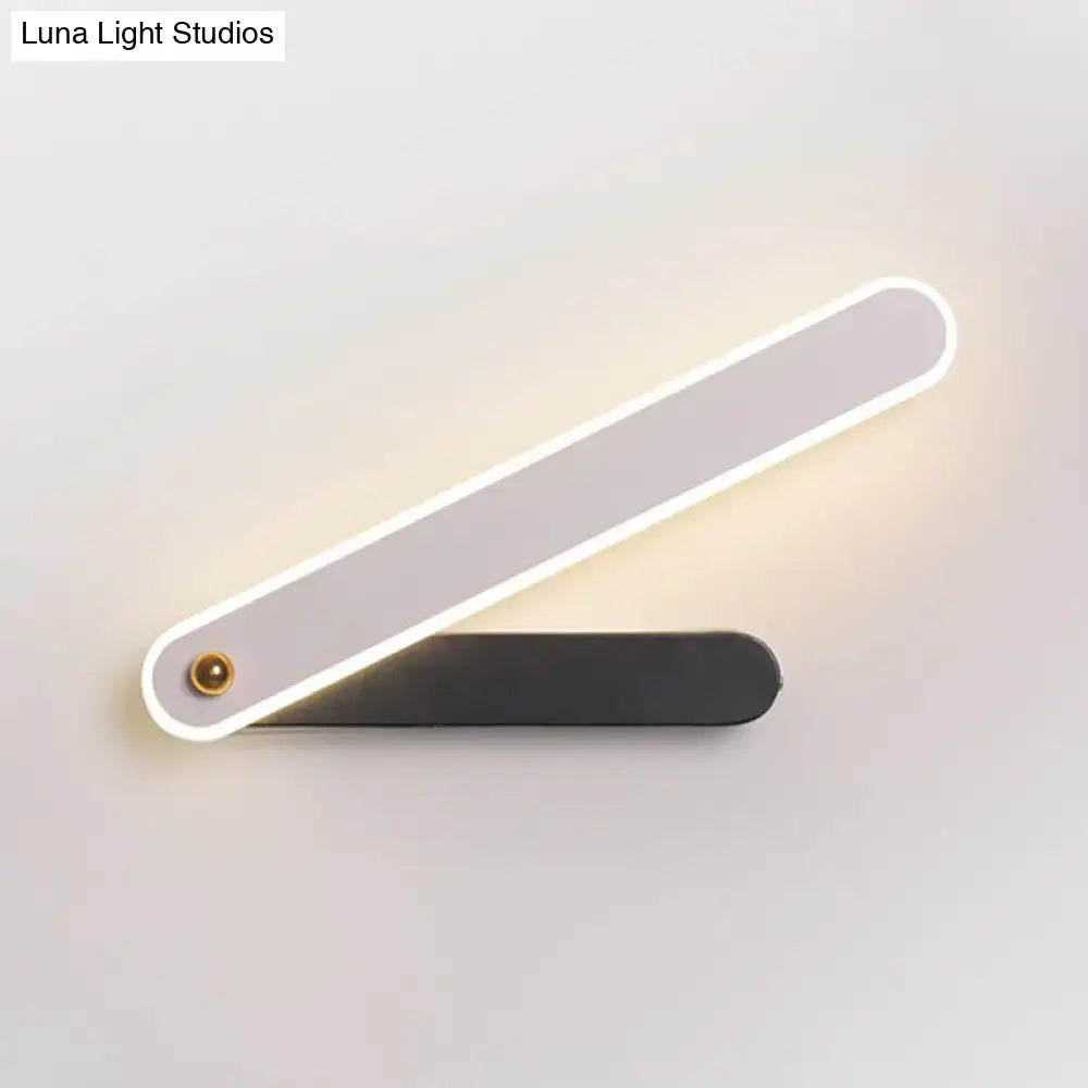 Modern black and white led wall mount fixture with sleek design and illuminated edge casting warm light for bedroom use