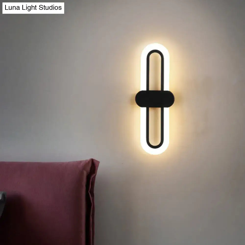 Modern black metal wall sconce with glowing white led light strip in elongated oval shape 110v-120v light type