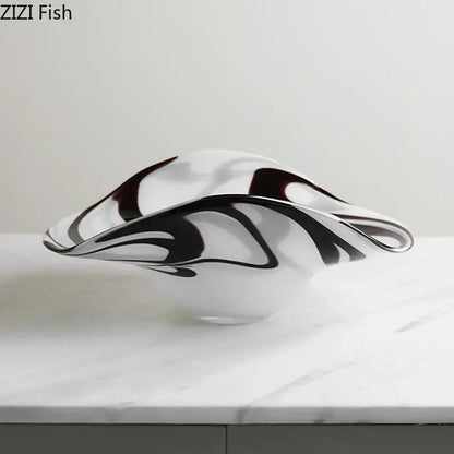 A modern glass fruit plate with sleek black and deep burgundy swirls on a translucent white base
