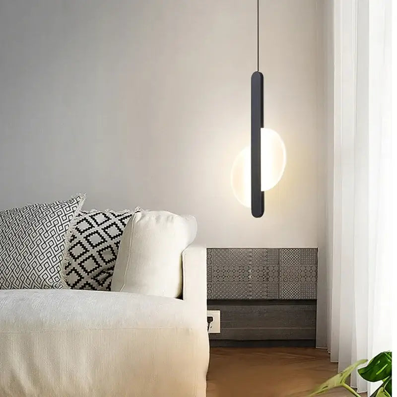 Modern black minimalist pendant light with sleek vertical bar and glowing led bulbs dining room light source