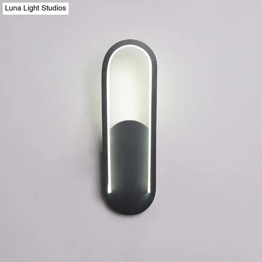 Modern black and white oval led wall sconce with a warm white color temperature and sleek minimalist design