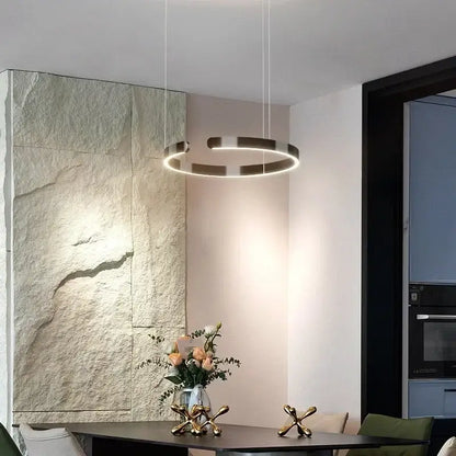Modern black and white ring pendant light with concentric brushed gold and matte black rings as an led light source