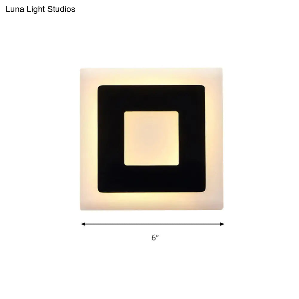 Modern black and white square wall sconce lamp with matte white frame black inner border and warm glowing light panel