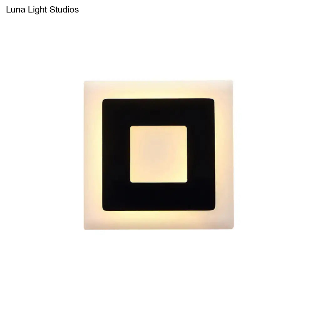 Modern black and white square wall sconce lamp with sleek black frame and cream glowing panel for bedroom lighting
