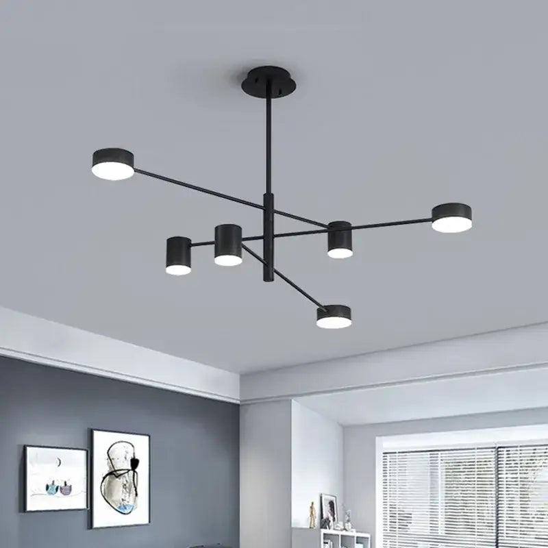 Modern black wrought iron chandelier with six cylindrical light fixtures arranged in a radial pattern for living room use