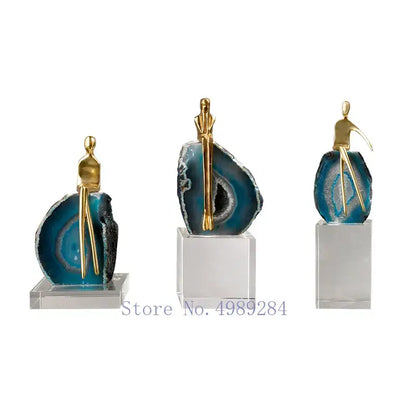 Set of three decorbites agate crystal golden sculptures with gold-toned figurines on blue agate bases for living room decor