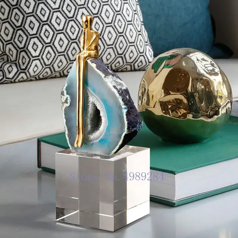A sleek blue and black decorbites agate crystal with a golden sculpture for modern living room decor
