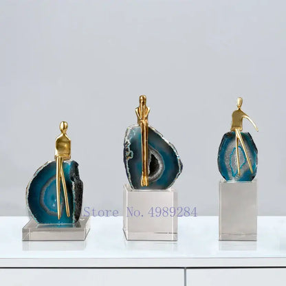 Three elegant gold-toned crystal golden sculptures on blue and black agate crystal bases by decorbites for living room decor