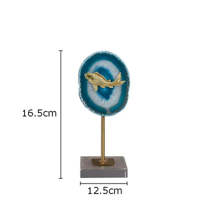 A golden fish figurine on a circular blue agate slice with brass stand by decorbites blue agate living room decor