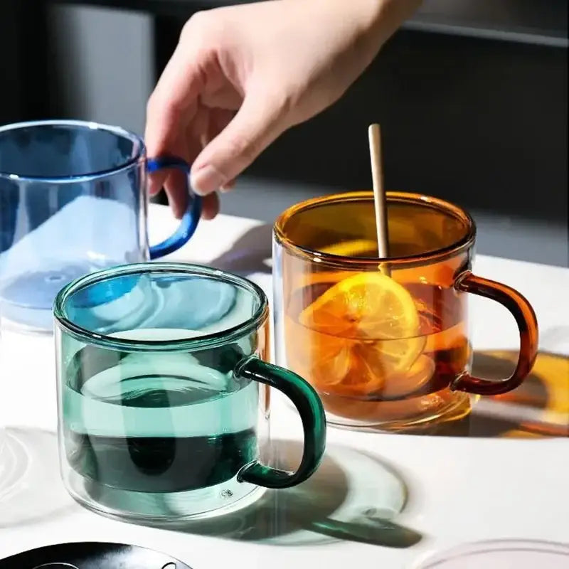 Modern blue amber and green glass mugs set features clear double-walled glass mugs in vibrant hues with matching handles