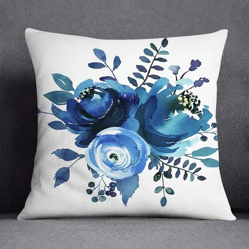 White throw pillow with geometric floral design featuring blue roses and green leaves for living room cushion