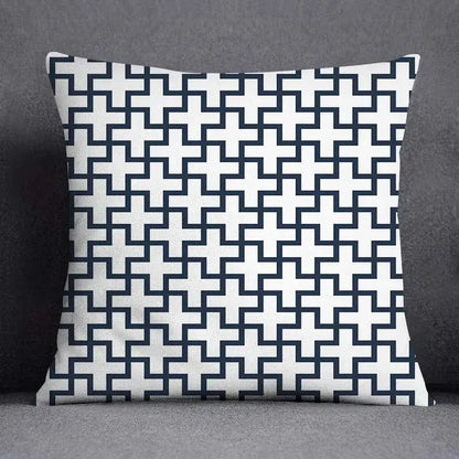 Square throw pillow with a modern blue geometric floral design of interlocking navy and white crosses on fabric surface