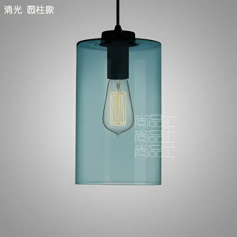 Modern blue glass led pendant lamp featuring a cylindrical shape, black metal fixture, and exposed Edison bulb for dining rooms
