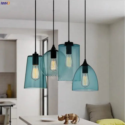 Set of four teal glass led pendant lights with black metal fixtures and exposed filament bulbs for dining room lighting