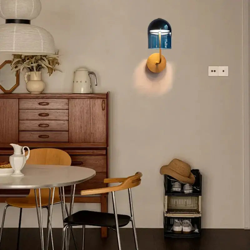 Modern blue glass wall lamp with gold-toned circular brass base for stylish bedroom decorbites blue glass wall lighting