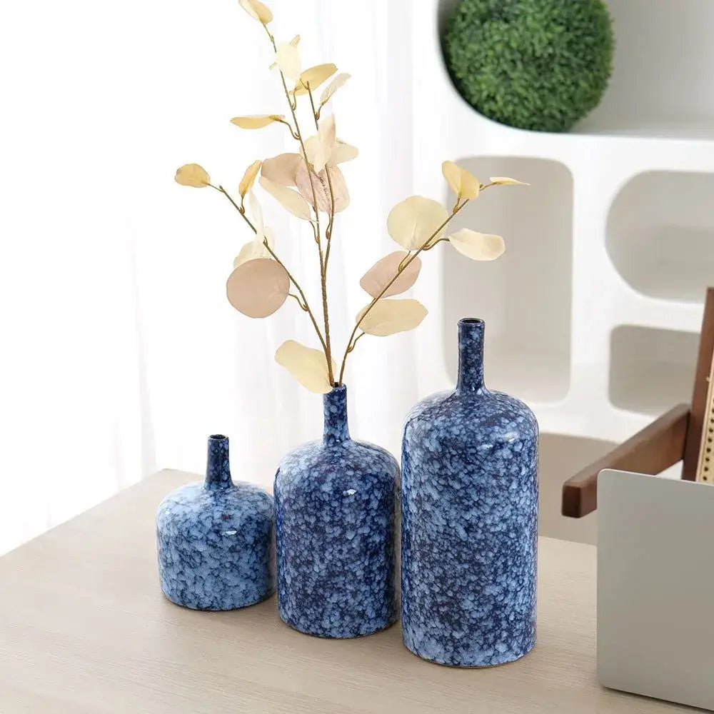 Three blue speckled ceramic vases with slender necks and rounded bodies perfect for decorbites blue ceramic accents