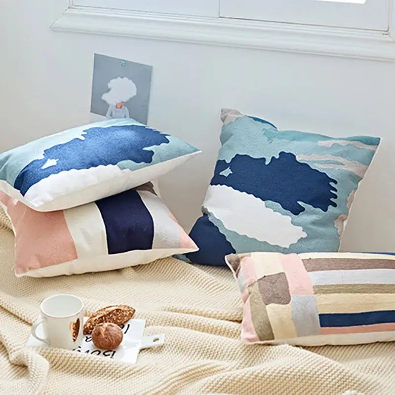 Soft textured cushion cover featuring embroidered geometric cotton design in blue white with pink and beige accents for bedroom