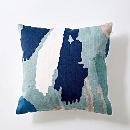 A modern blue and white embroidered geometric cotton cushion cover with abstract navy teal and beige design for bedroom
