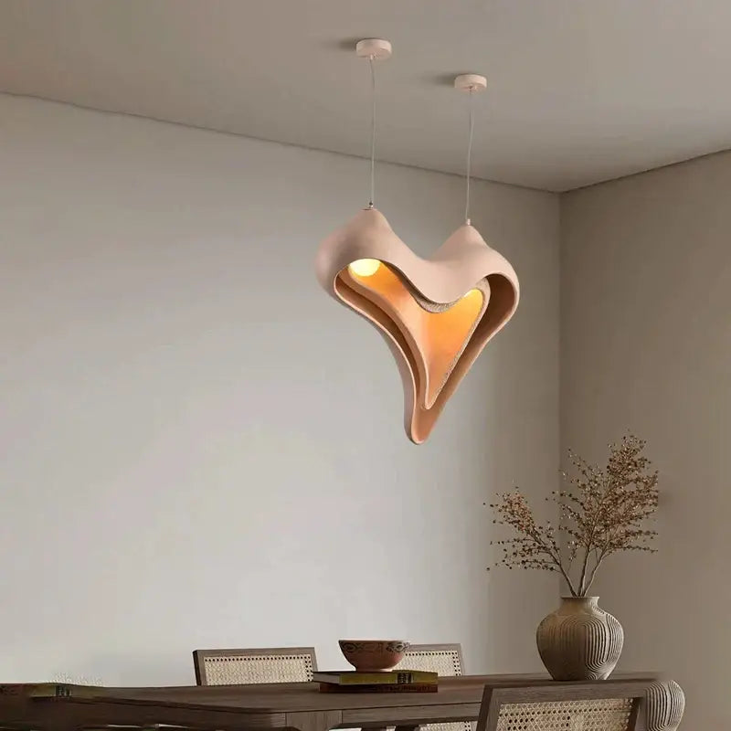 Modern blush pink ceramic pendant light with sculptural design and warm amber glow for dining room decorbites conch chandelier
