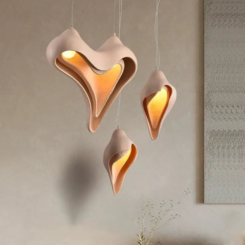 Three blush pink ceramic pendant lights with warm amber interiors from decorbites conch chandelier for dining room decor