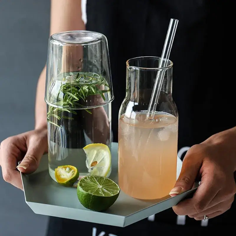 Modern borosilicate glass drinkware set featuring a clear pitcher with narrow neck and pink lemonade with ice cubes
