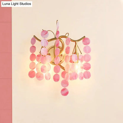 A delicate pink branch design wall lamp with gold metal frame and translucent glass discs for bedroom sconce use