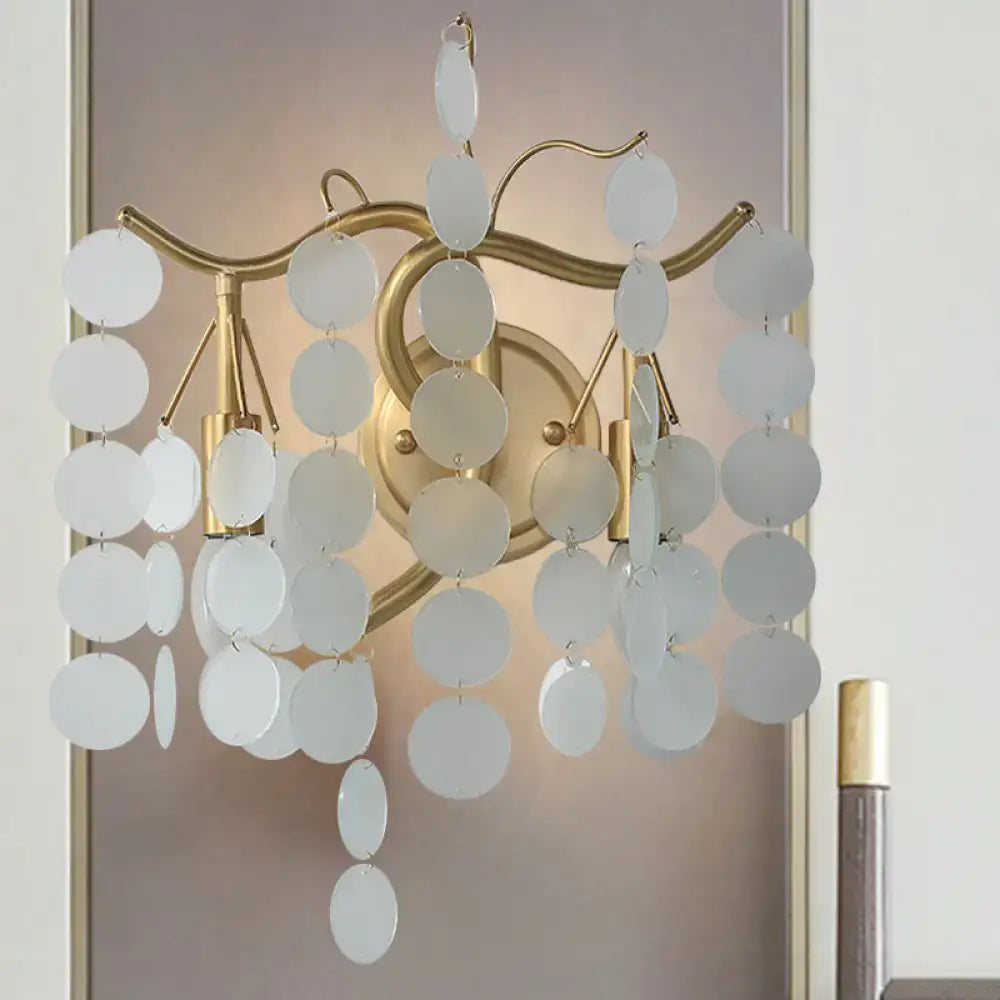 A delicate white circular disc chandelier with gold metal frame complements modern branch design wall lamp bedroom sconce