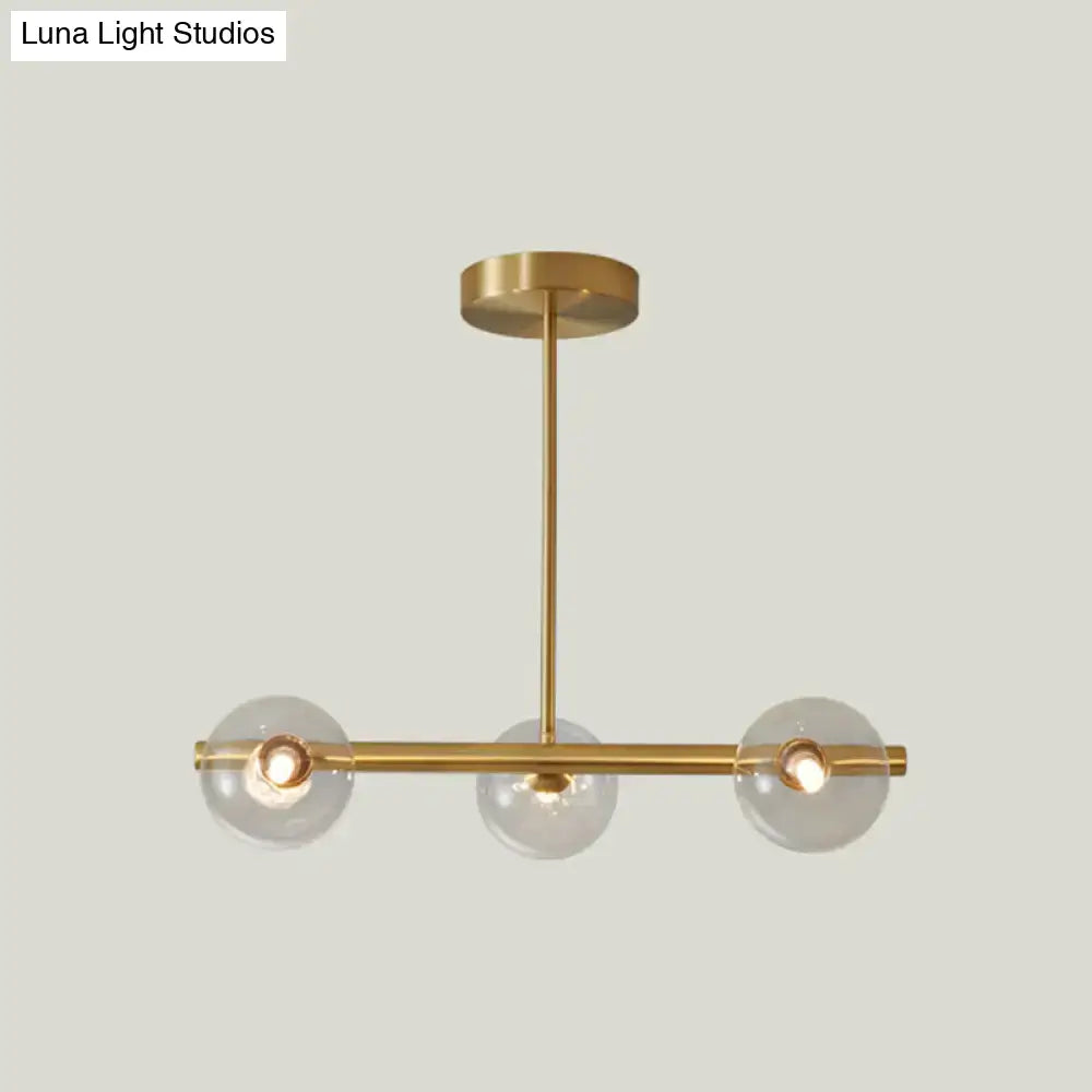 Modern brass 5-light pendant light with spherical glass shades and a sleek horizontal bar design for dining room