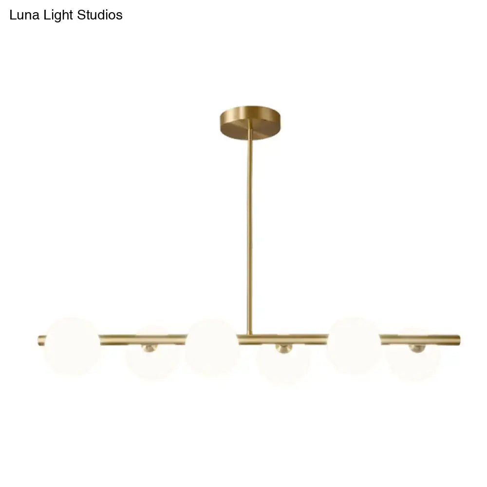 Modern brass 5-light pendant light with minimalist horizontal bars and frosted spherical glass shade for dining room