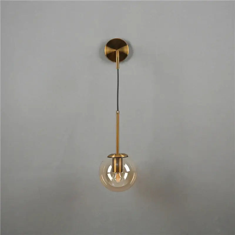 Minimalist modern brass amber glass ball wall lamp with spherical glass globe and exposed filament bulb for bedroom decorbites glass ball