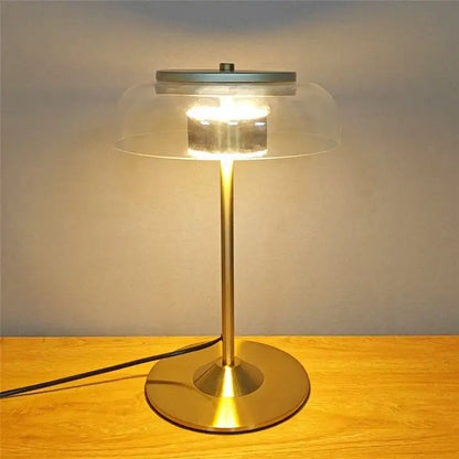 A sleek brass-finished table lamp with transparent amber glass dome from decorbites elegant mushroom glass collection